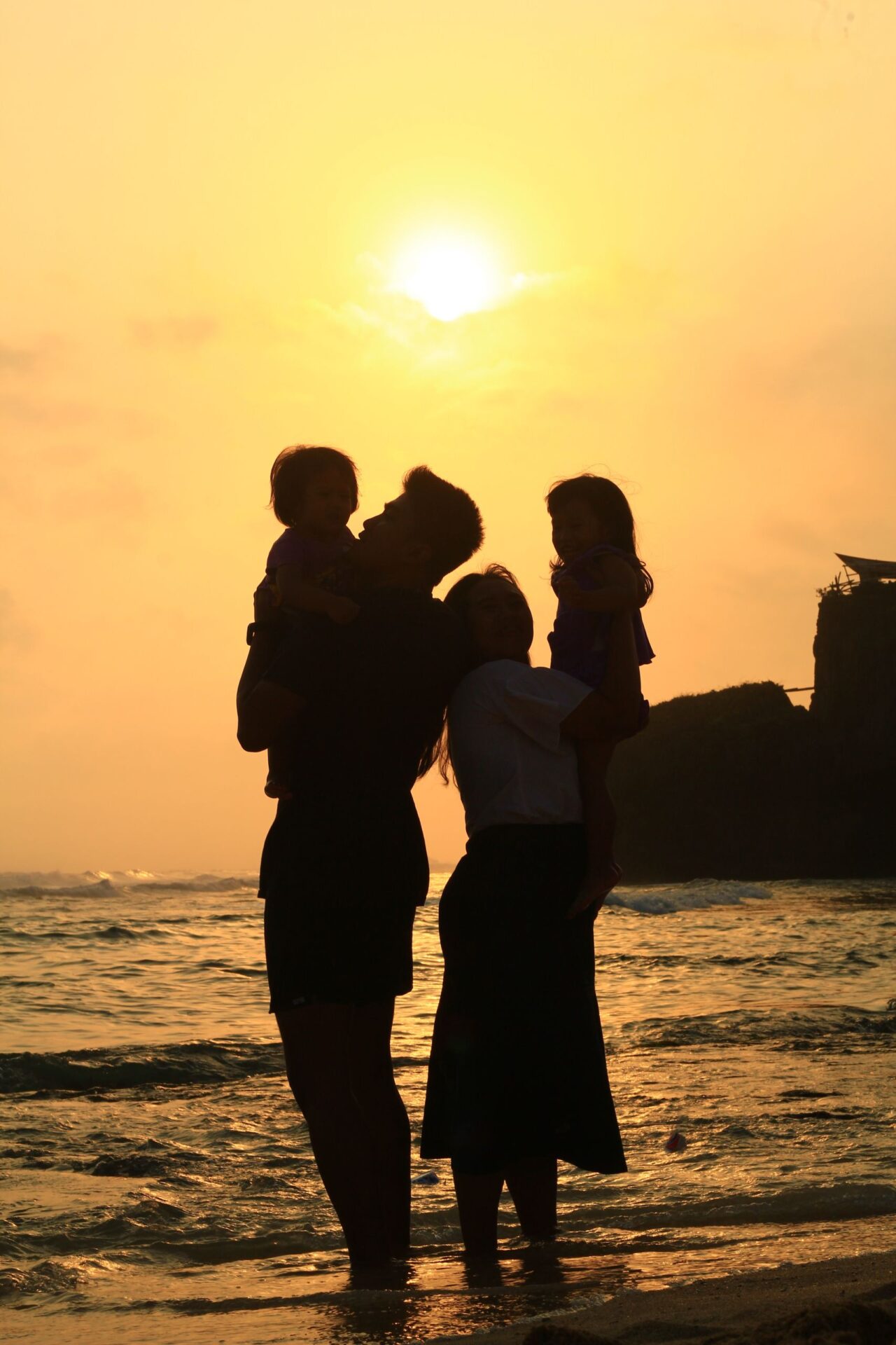 A family enjoying a scenic sunset on the beach, capturing a beautiful moment of togetherness.