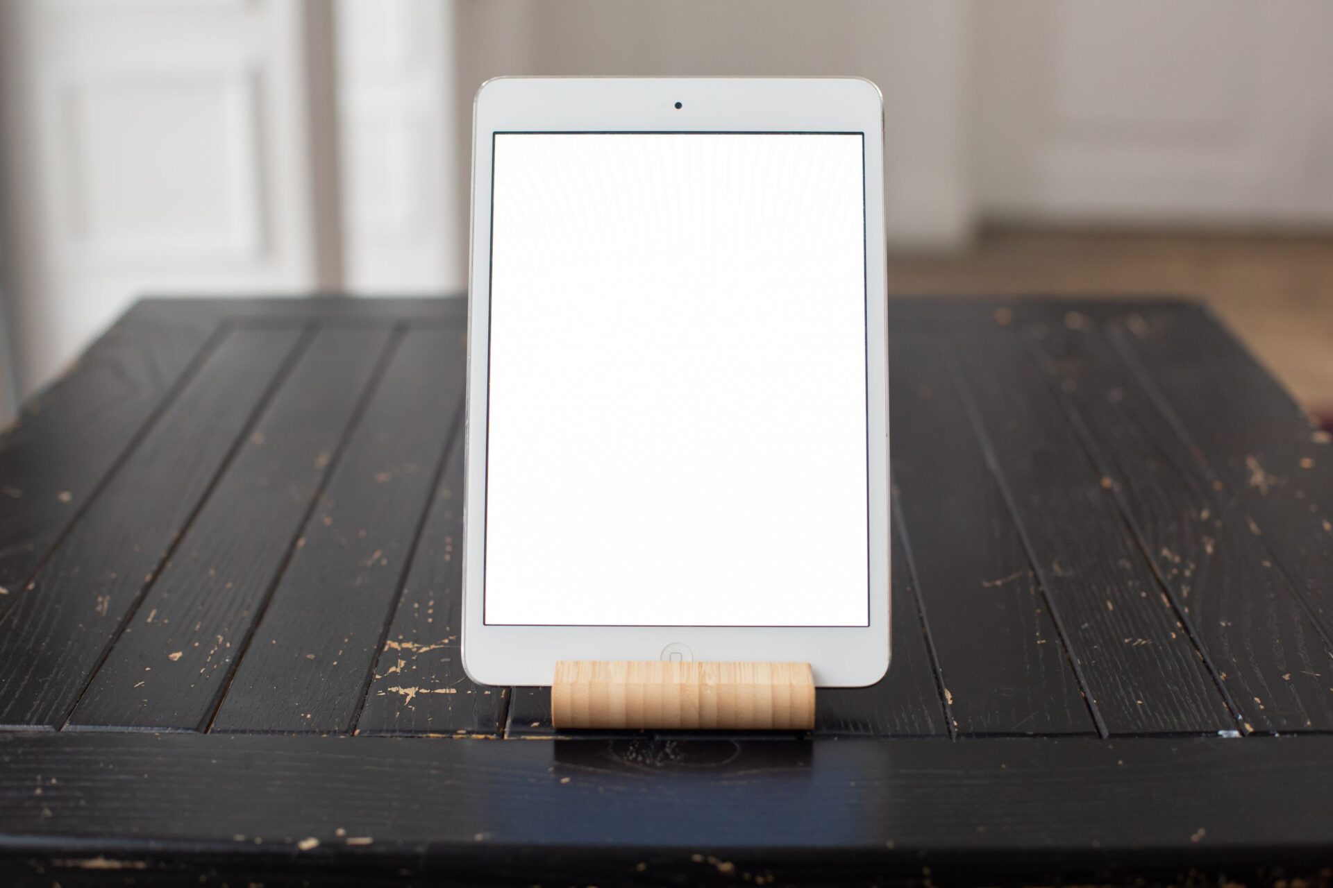 A sleek tablet with a blank screen displayed on a rustic wooden table, perfect for mockups.