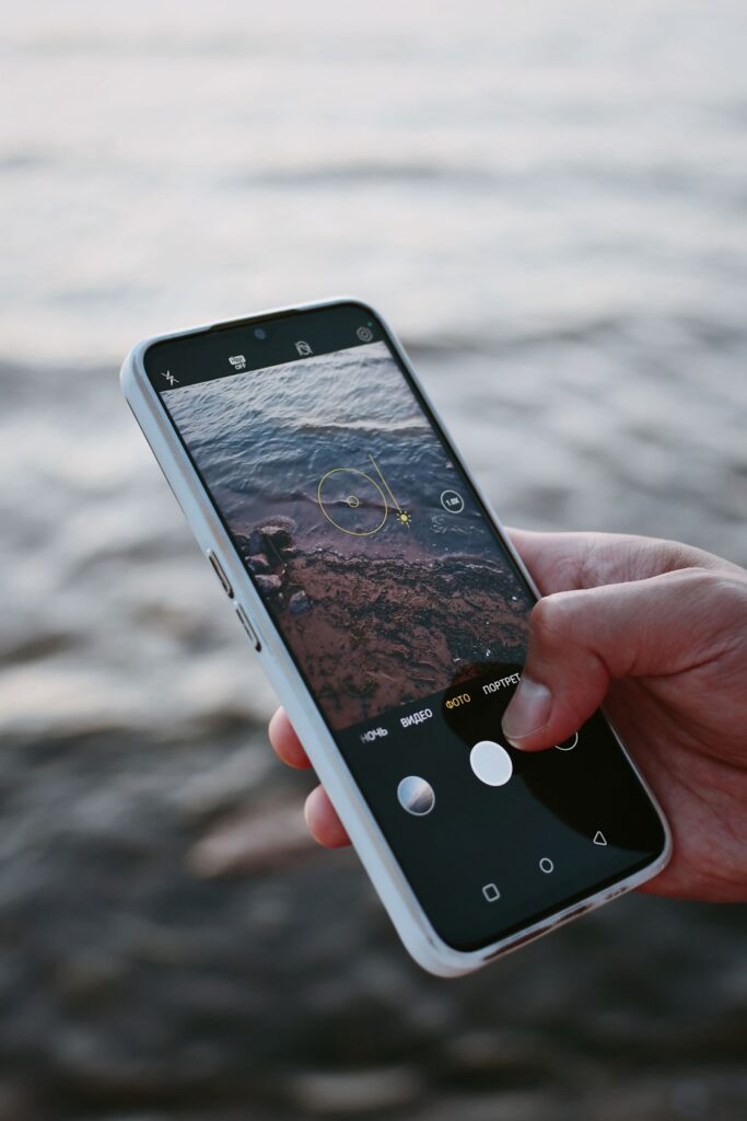 現在の画像: A smartphone capturing ocean waves, highlighting modern mobile photography.