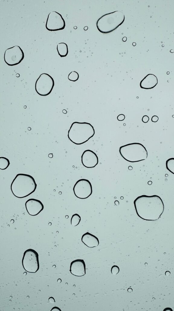 現在の画像: Abstract image of water droplets on a glass surface creating a serene, minimalist pattern.