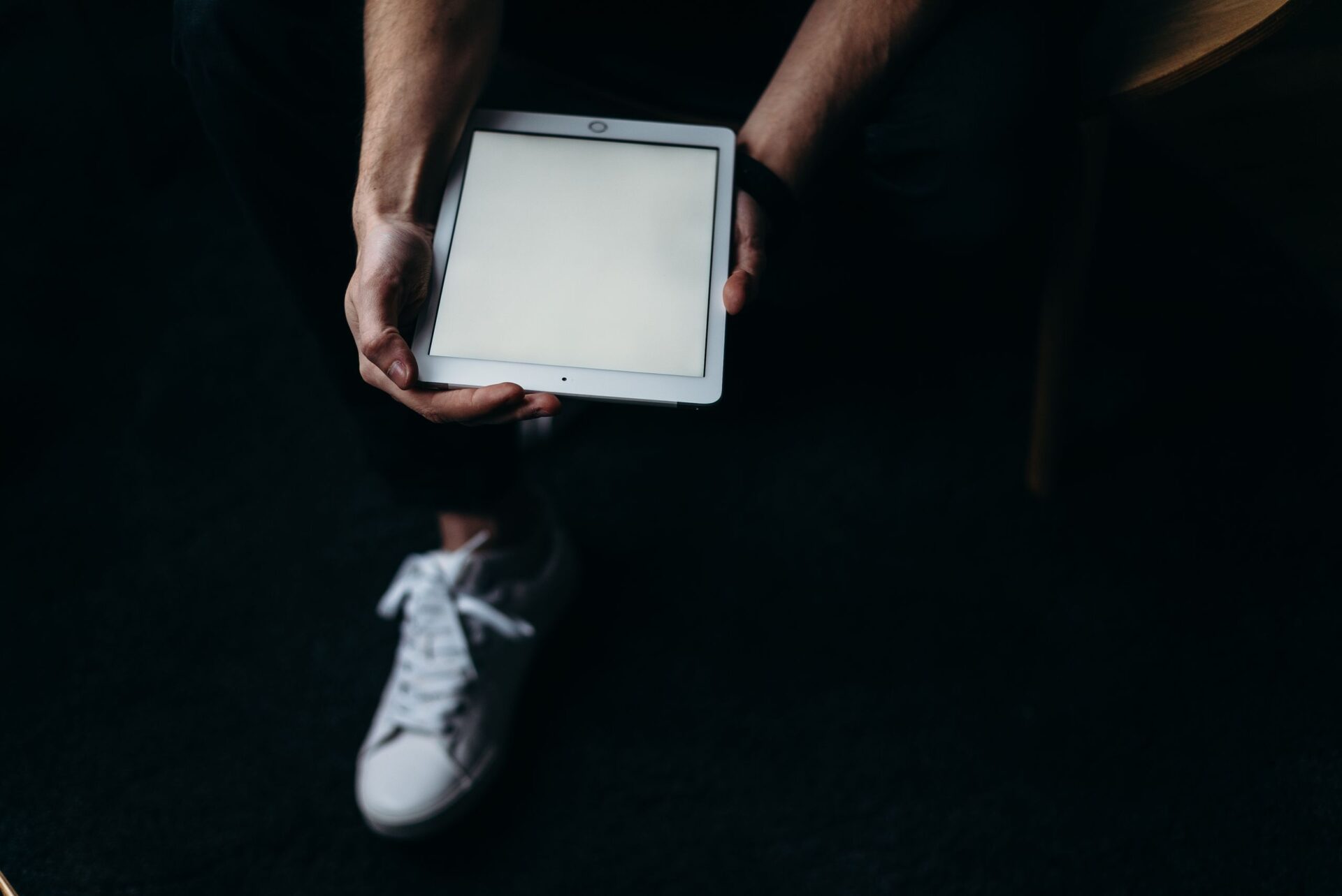 An adult holding a tablet with a blank screen, ideal for technology or business concept themes.