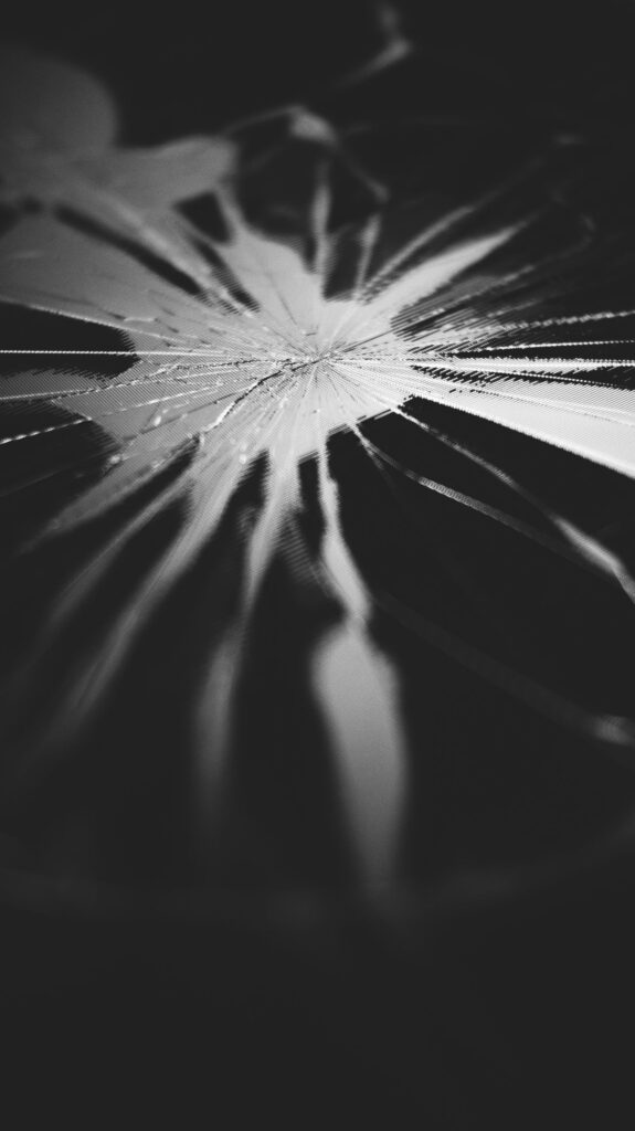 現在の画像: Artistic black and white close-up of a cracked glass surface highlighting textures and patterns.