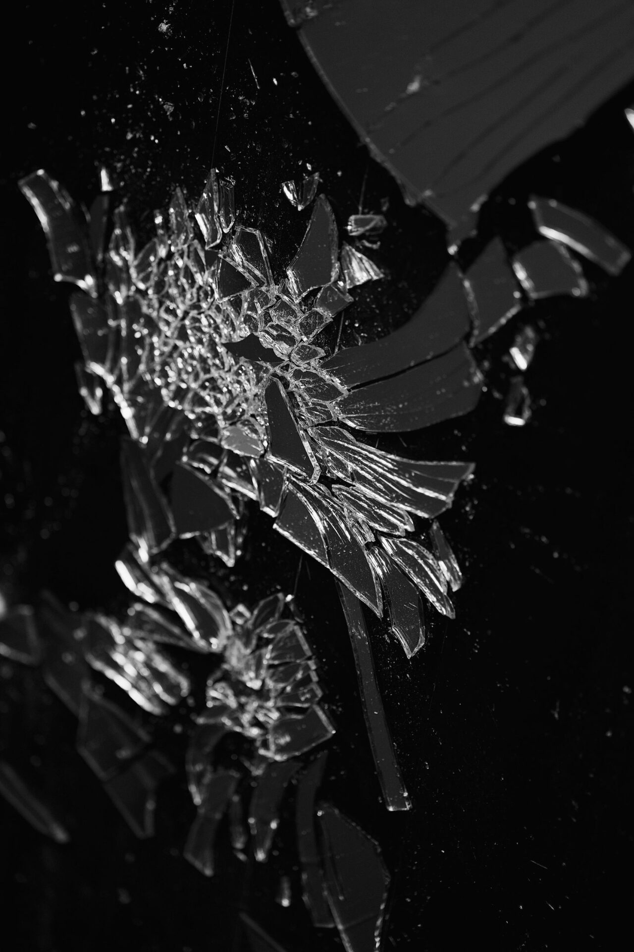 Artistic black and white photo of shattered glass with intricate patterns.