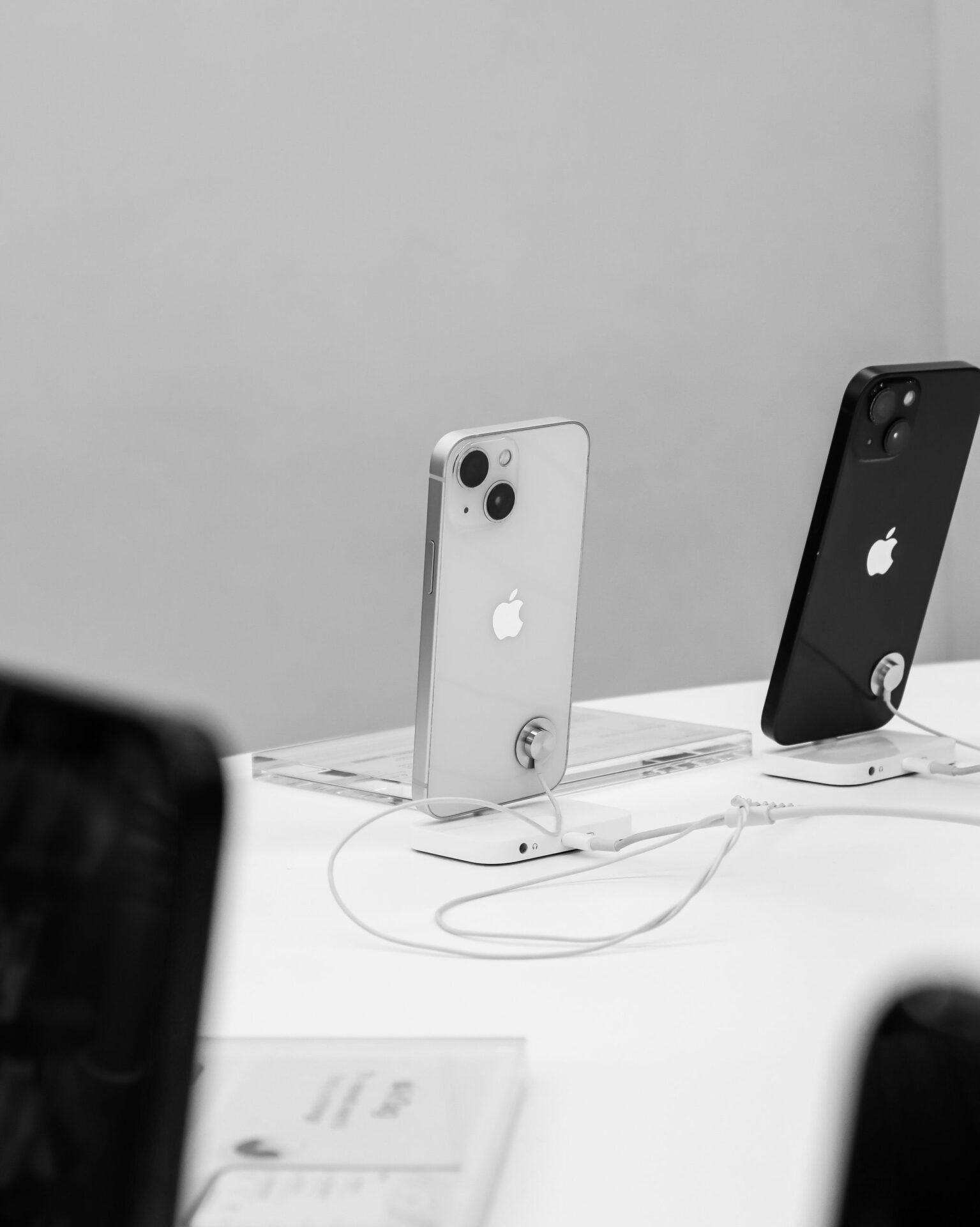 Black and white display of modern smartphones in a store setting, showcasing technology.