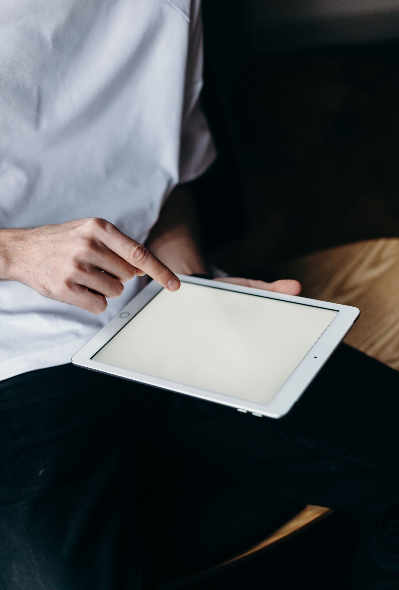 Close-up of a man touching a blank tablet screen, perfect for tech or business themes.
