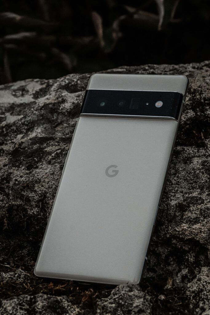Close-up of a sleek camera phone on textured stone, showcasing modern design.