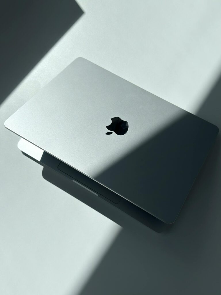 現在の画像: Closed silver laptop bathed in contrast lighting, minimalistic tech elegance.