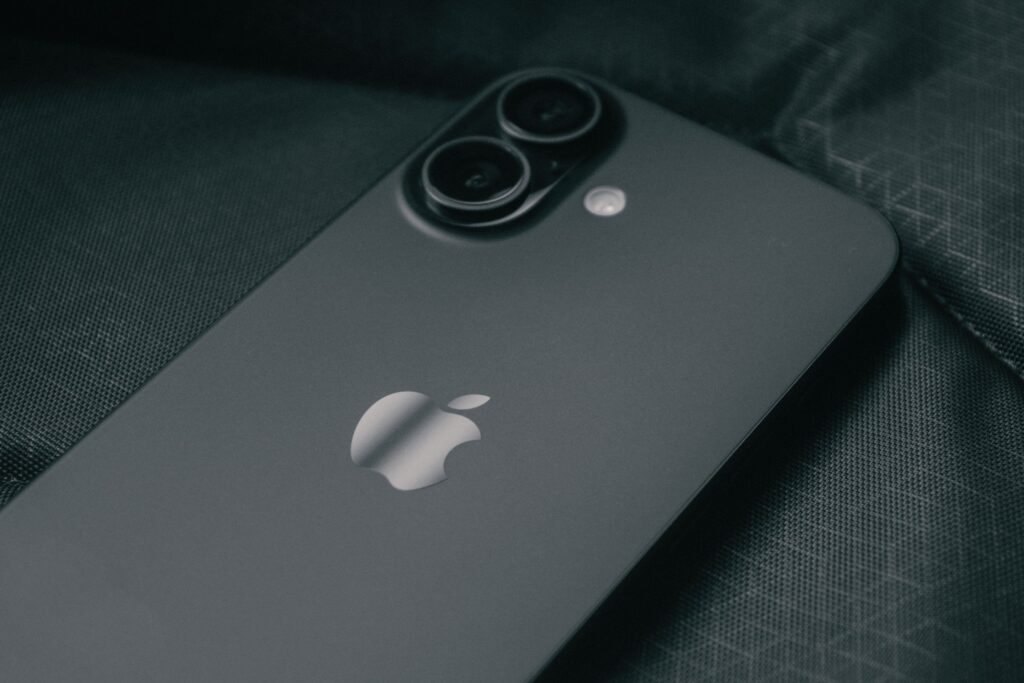 現在の画像: Detailed close-up of a modern smartphone on a textured dark fabric background.