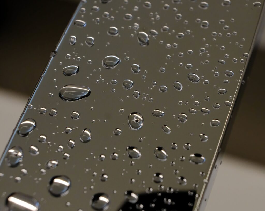 現在の画像: Detailed photo of water droplets on a glass surface, creating a reflective and clean aesthetic.