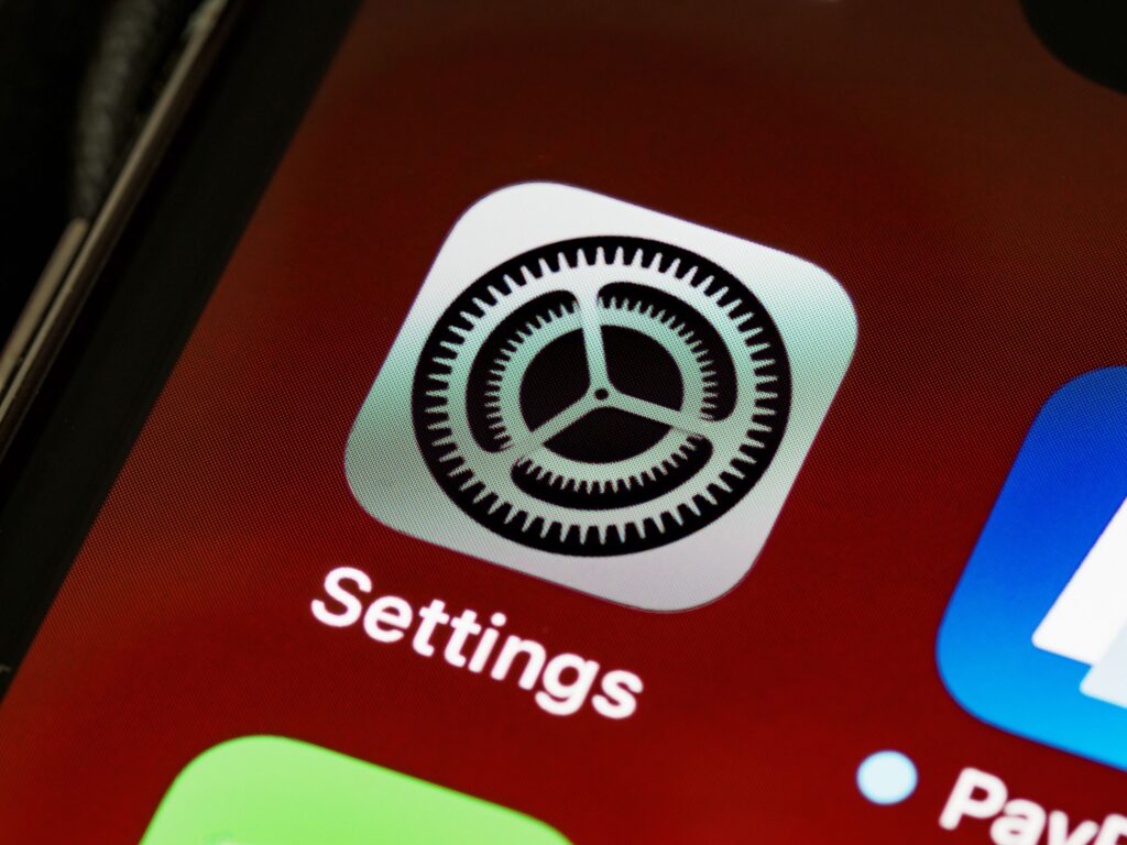 現在の画像: Detailed view of the iPhone screen showing the settings app icon.
