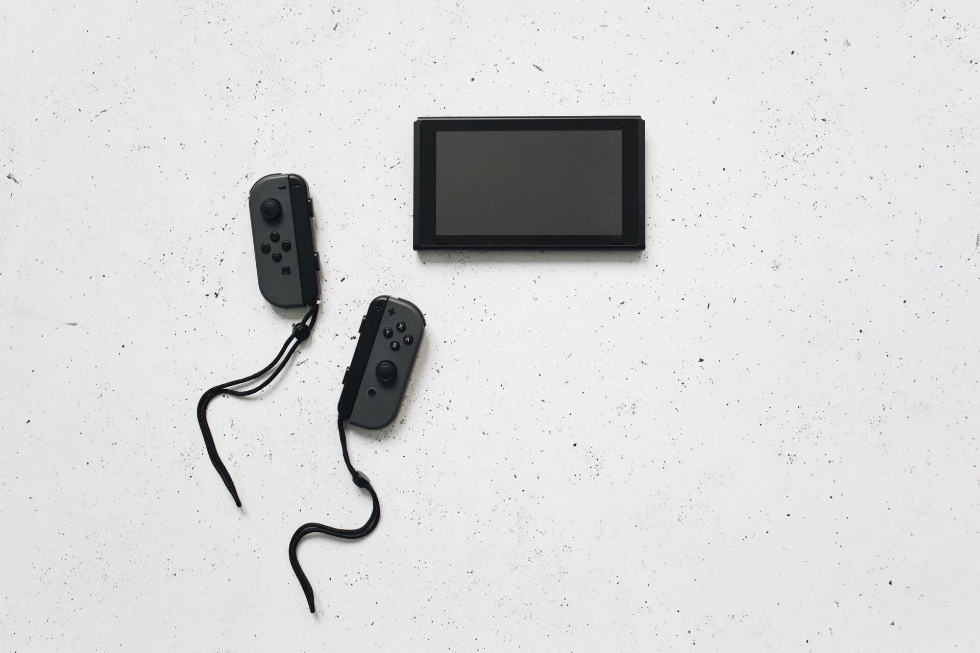 Flat lay of a sleek gaming console with wireless controllers on a white background.