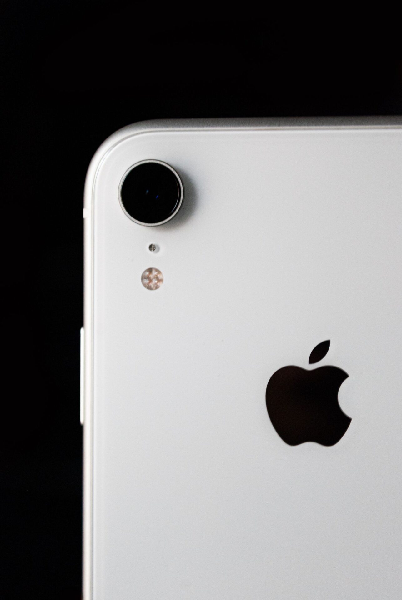 High-resolution close-up of a smartphone's camera lens against a black background.