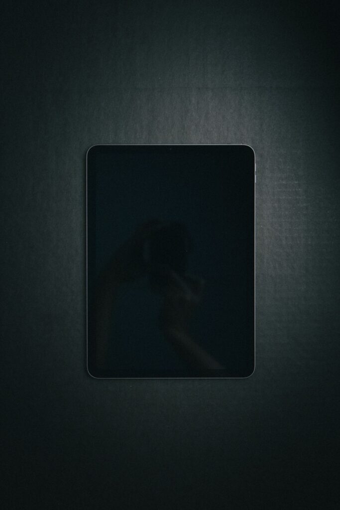 現在の画像: Minimalist photo of a sleek tablet with black surface, perfect for tech themes.