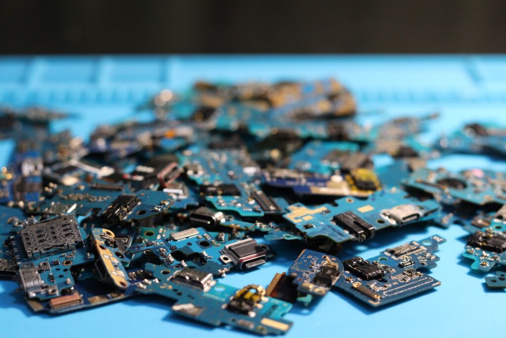 現在の画像: Pile of disassembled circuit boards on a blue surface. Perfect for tech themes.