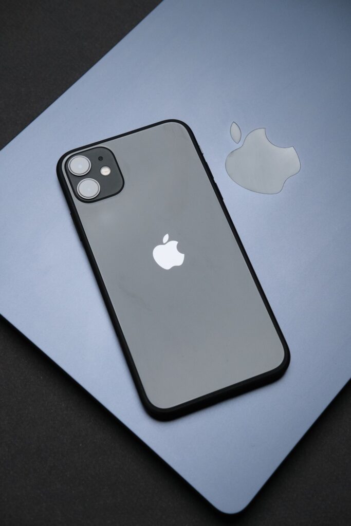 現在の画像: Stylish Apple iPhone on a MacBook, showcasing modern technology and design.